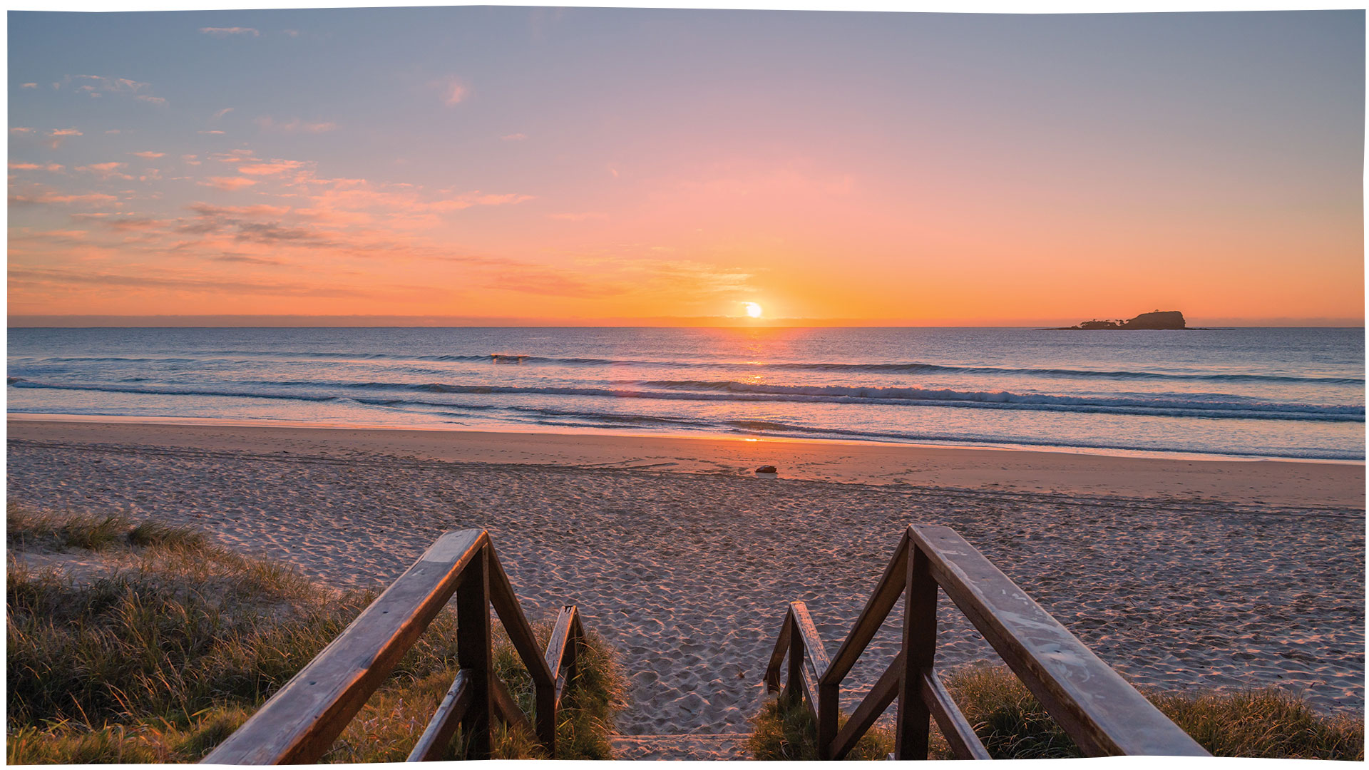 Direct Cremation Sunshine Coast Costs & Local Support Sunrise over a sandy beach with calm ocean waves and a small island in the distance.