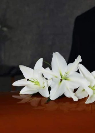Casket With White Lilies — Newhaven Funerals in Brisbane