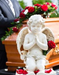 Red Rose On Angel Statue — Newhaven Funerals in Brisbane