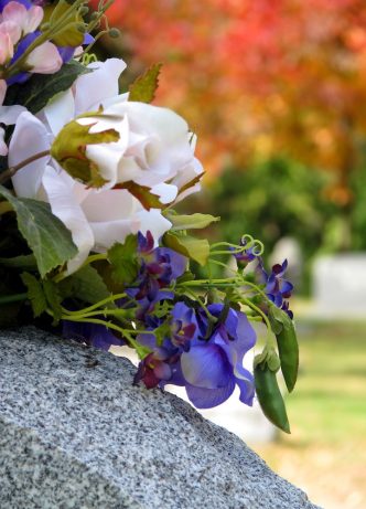 Silk Flowers On A Cemetery Grave Headstone — Newhaven Funerals in Brisbane