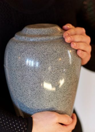Woman Holding Urn — Newhaven Funerals in Brisbane