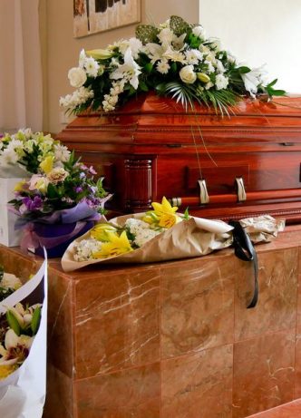 Casket Surrounding By Flowers — Newhaven Funerals in Brisbane
