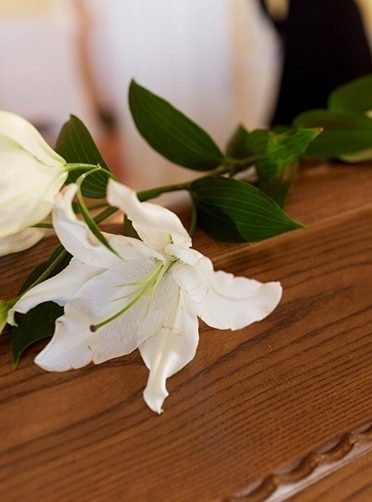 White Lily Flower on Coffin — Newhaven Funerals in Brisbane